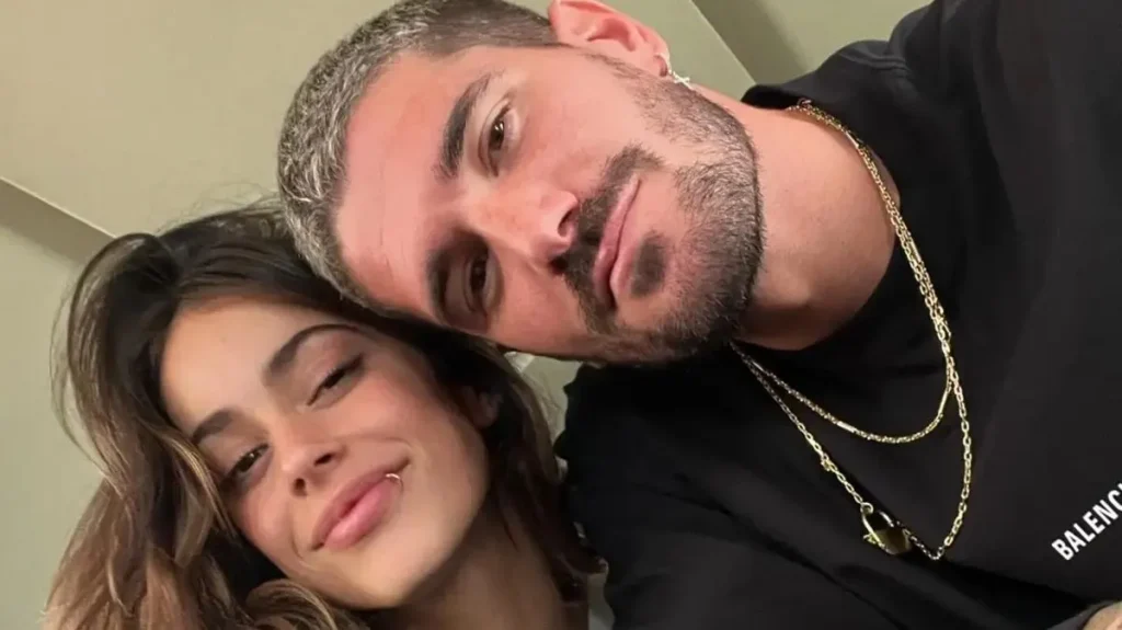 Emilia Mernes y Duki sonriendo y abrazados, mirando a cámara.