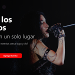 YSY A en un concierto con el micrófono en la mano y las luces del escenario de fondo
